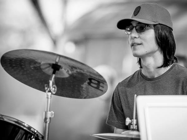Teenage drummer sits behind a drum set